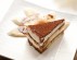 A slice of the Italian delicacy tiramisu and several piece of banana on dish